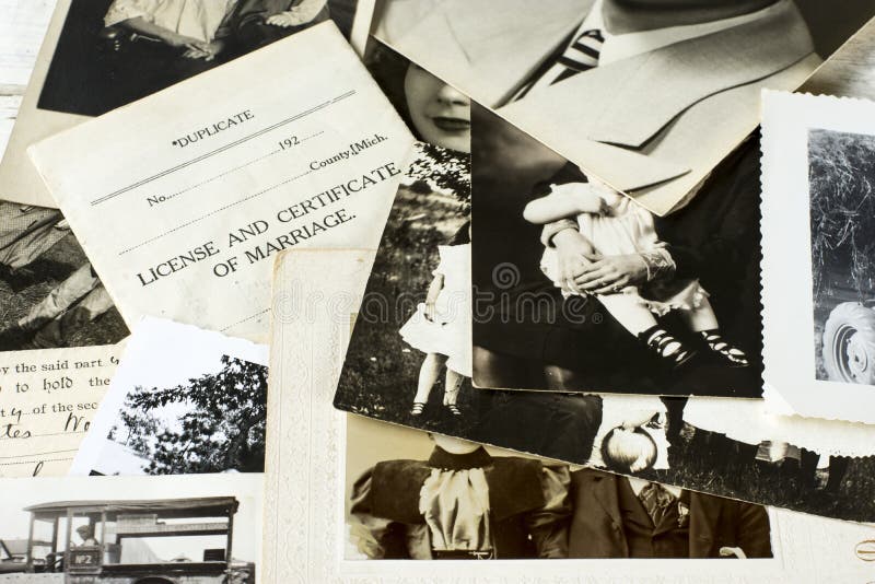 Nostalgic family photographs and genealogy documents laid out for research